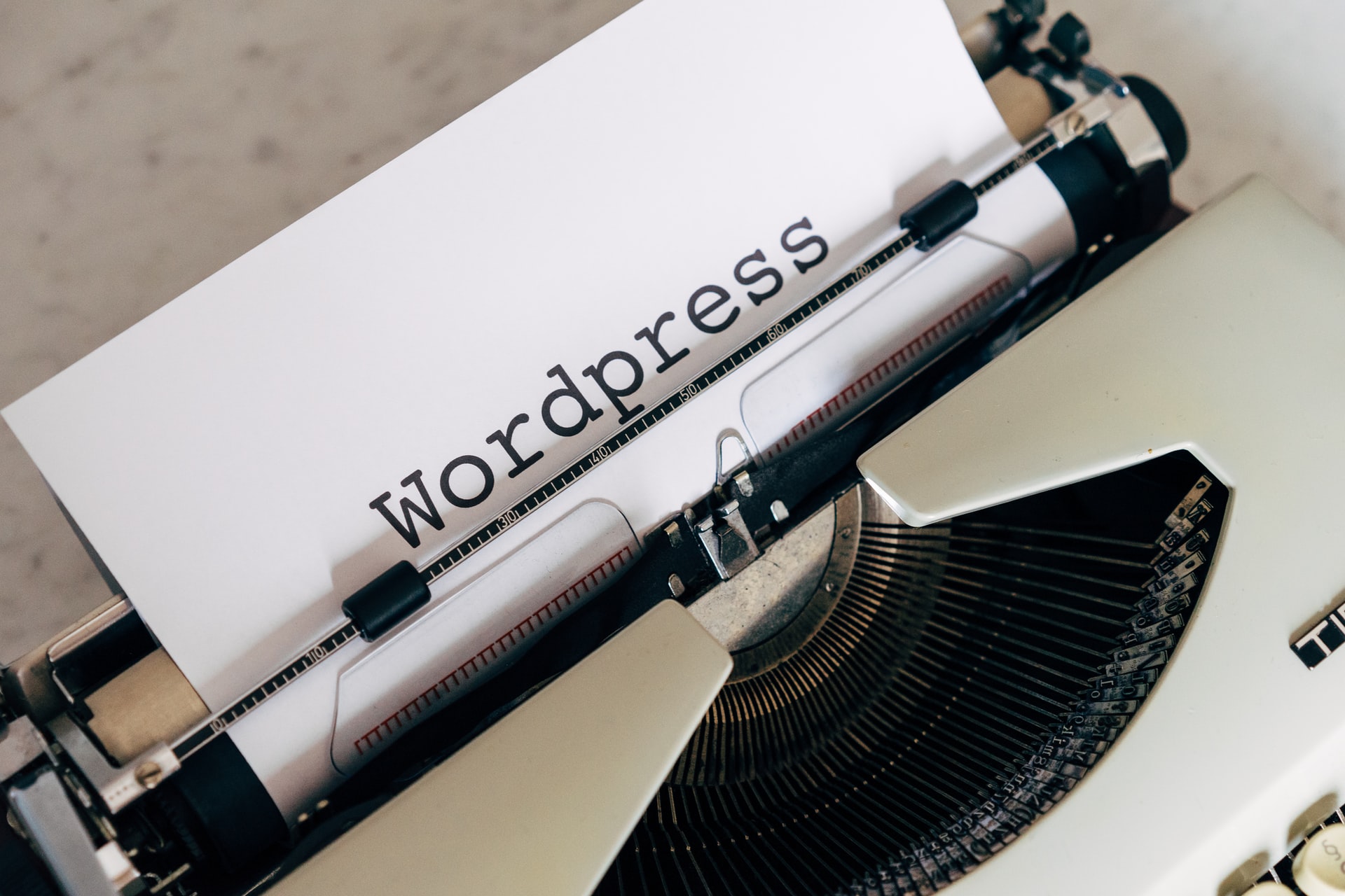 a typewriter displaying a piece of paper with the words Wordpress